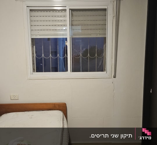 חלון עם תריסים סגורים ומסגרת לבנה
